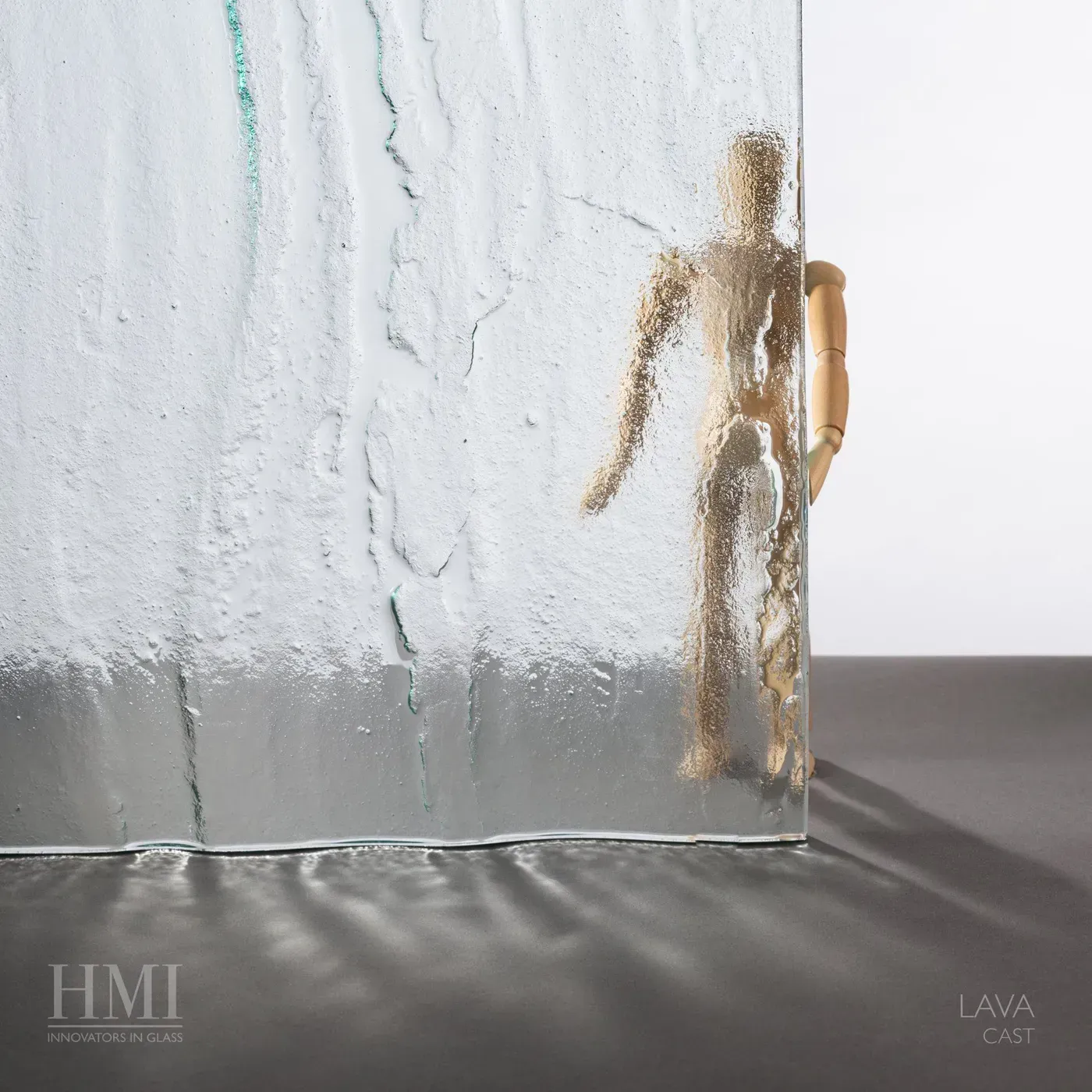 A wooden artist's mannequin stands behind a sheet of textured