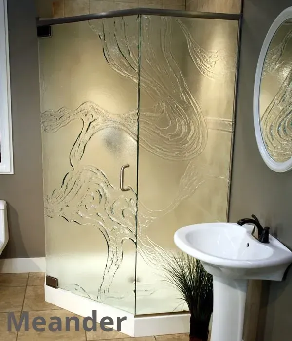 A corner shower stall with frosted glass featuring an etched, flowing organic