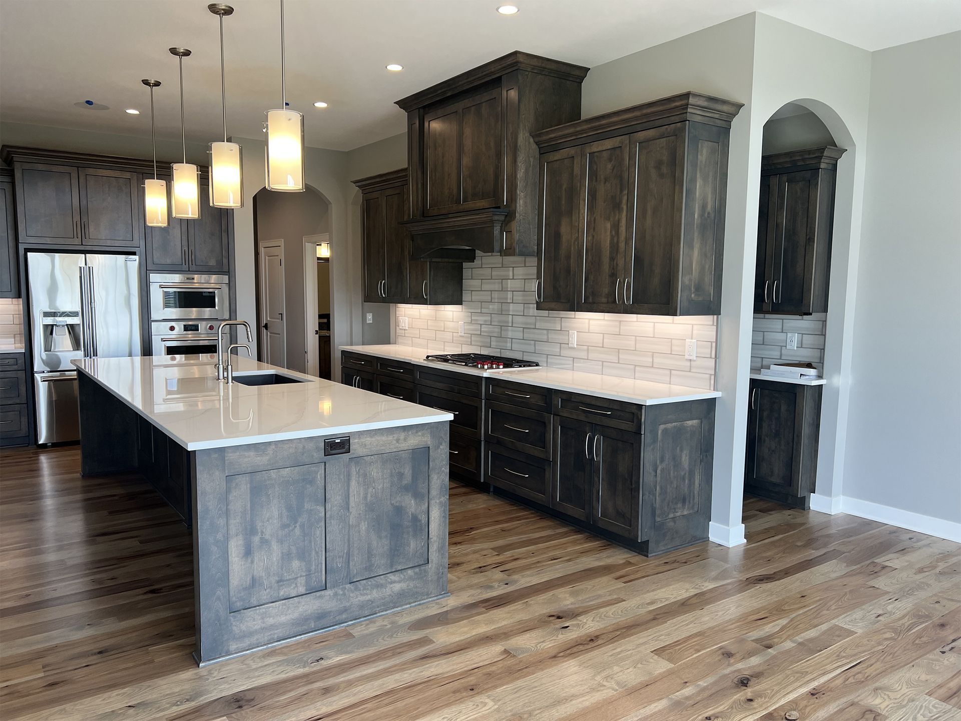 Modern kitchen with wood cabinets, white countertops, and island.