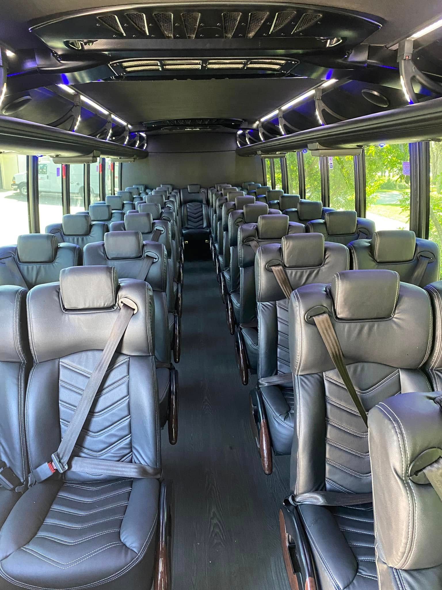 Interior of a modern coach bus with rows of empty gray leather seats and large windows