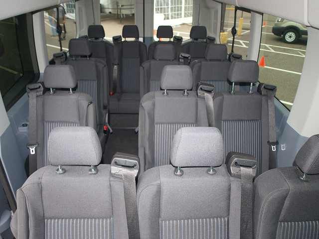 Empty gray shuttle bus interior with rows of seats and large windows