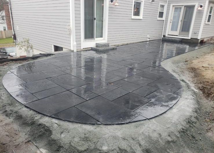 A patio is being built in front of a house.