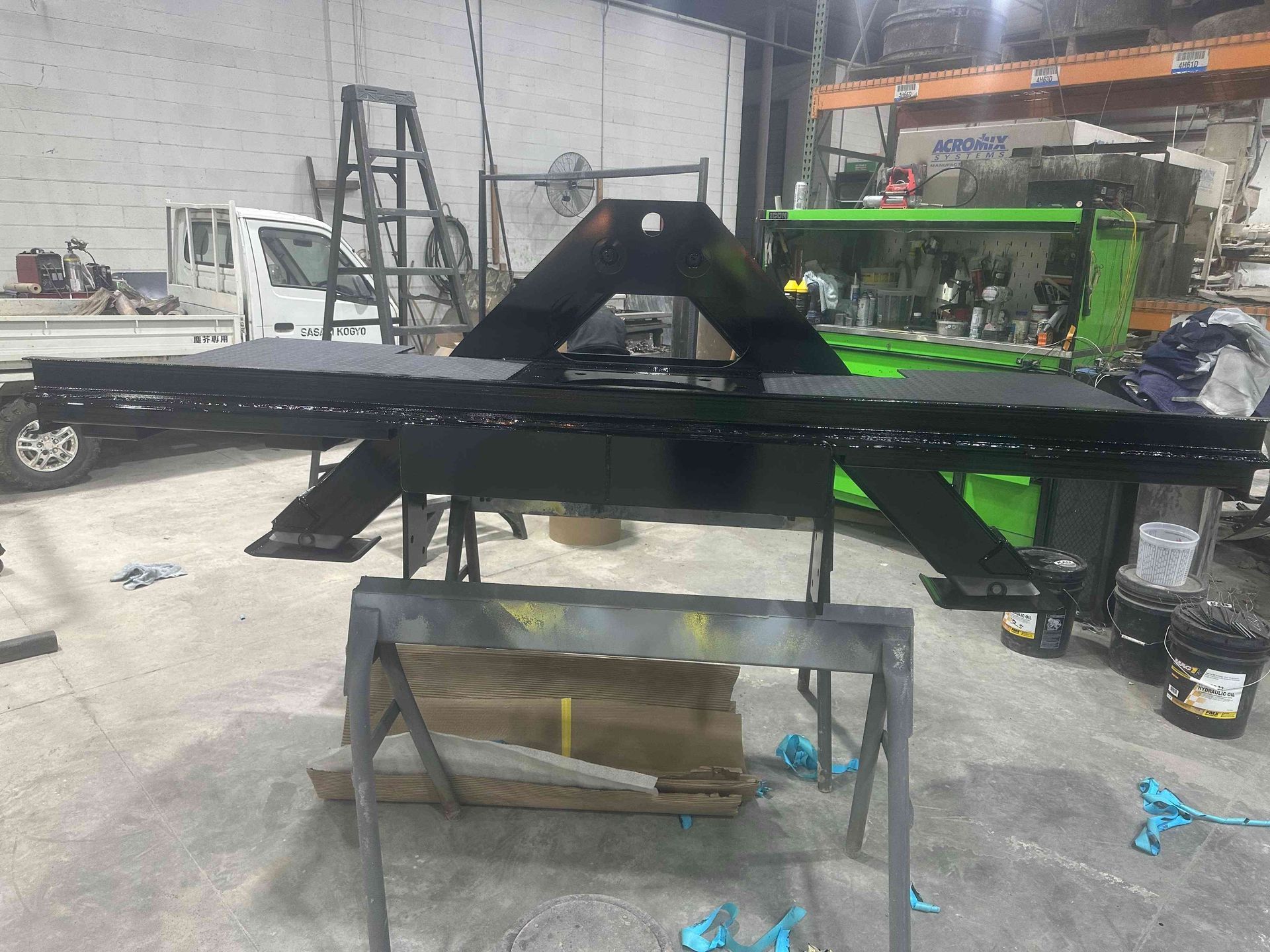 Black and green metal equipment frame on a workbench in an industrial workshop