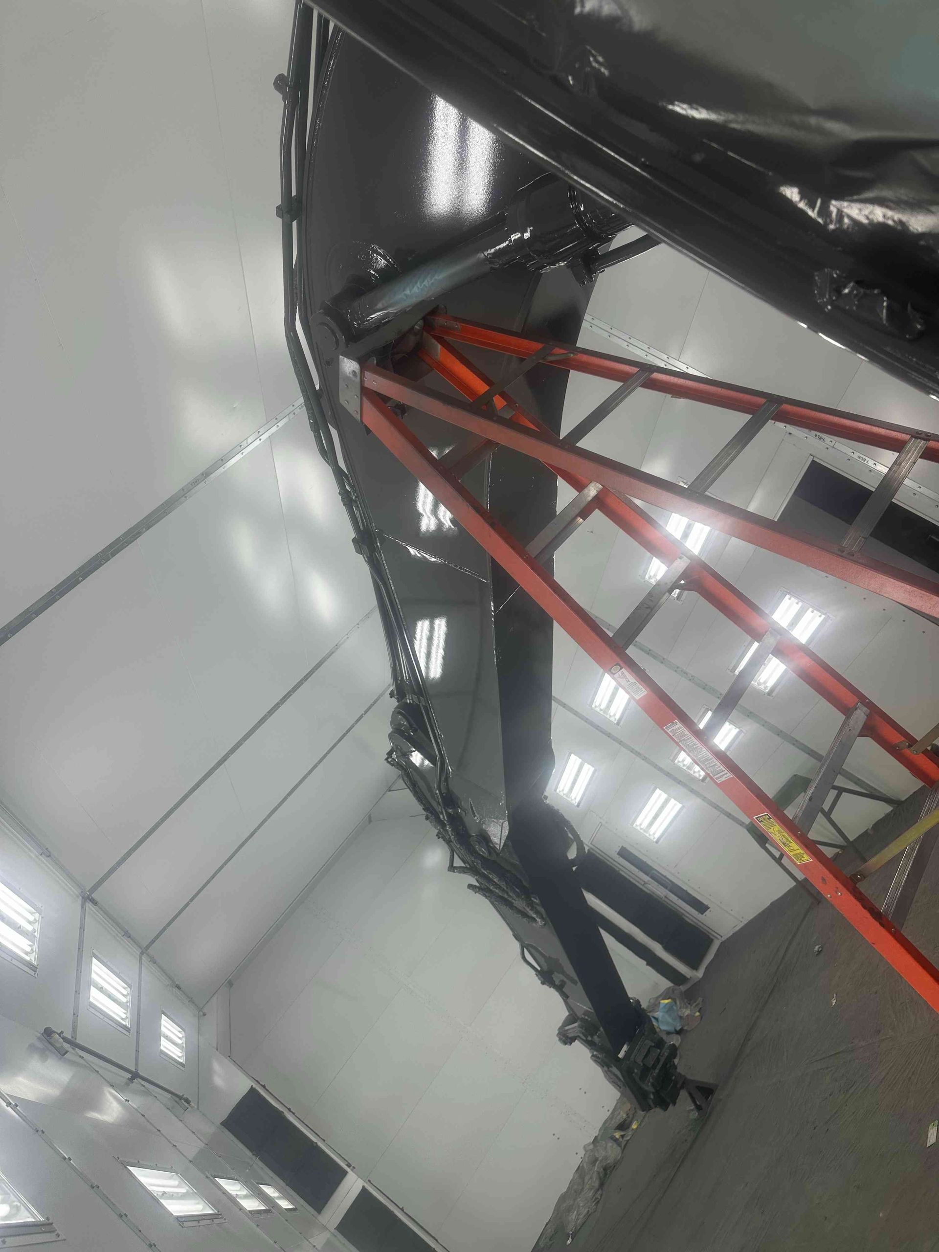 Tilted view of an indoor sports court with a red metal hoop and bright overhead lights