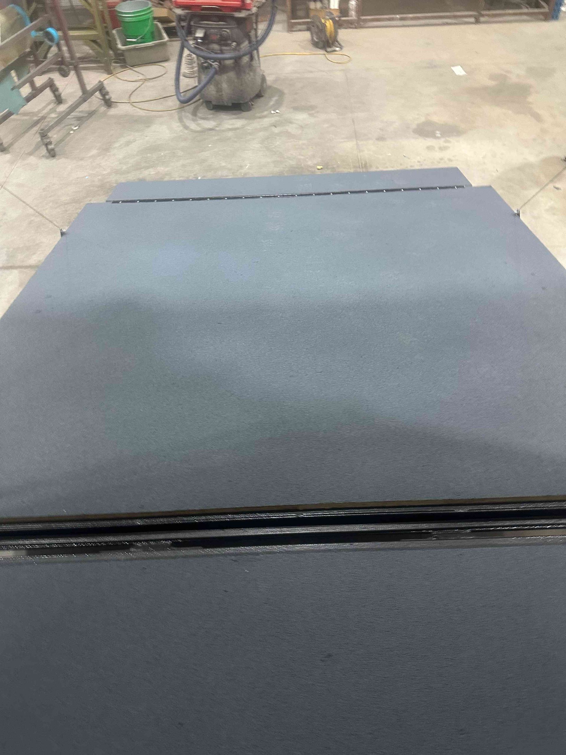 Dark gray flat surface with a rough outdoor background at the top edge