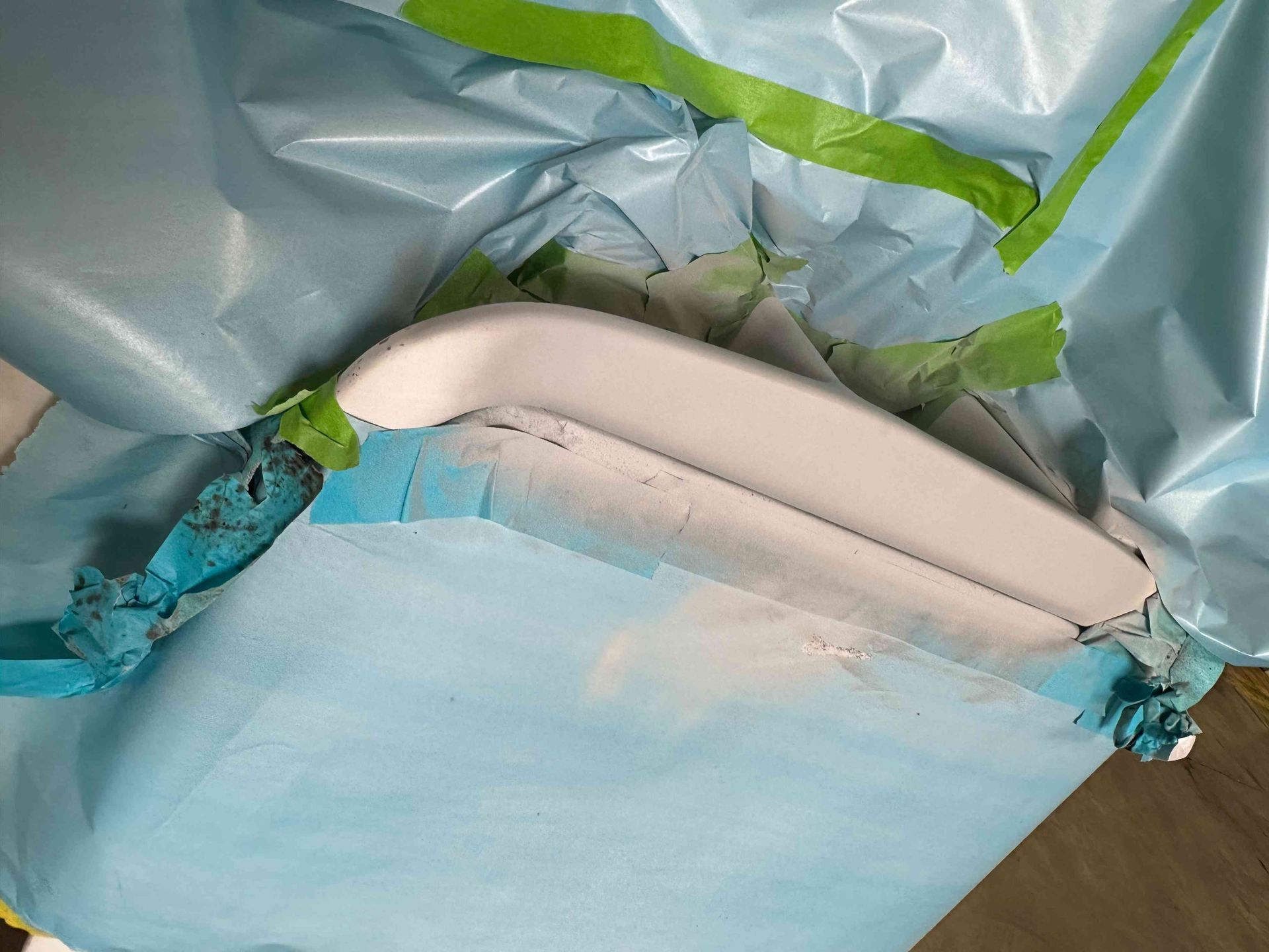 Blue trash bag filled with a white object and green-trimmed plastic liner