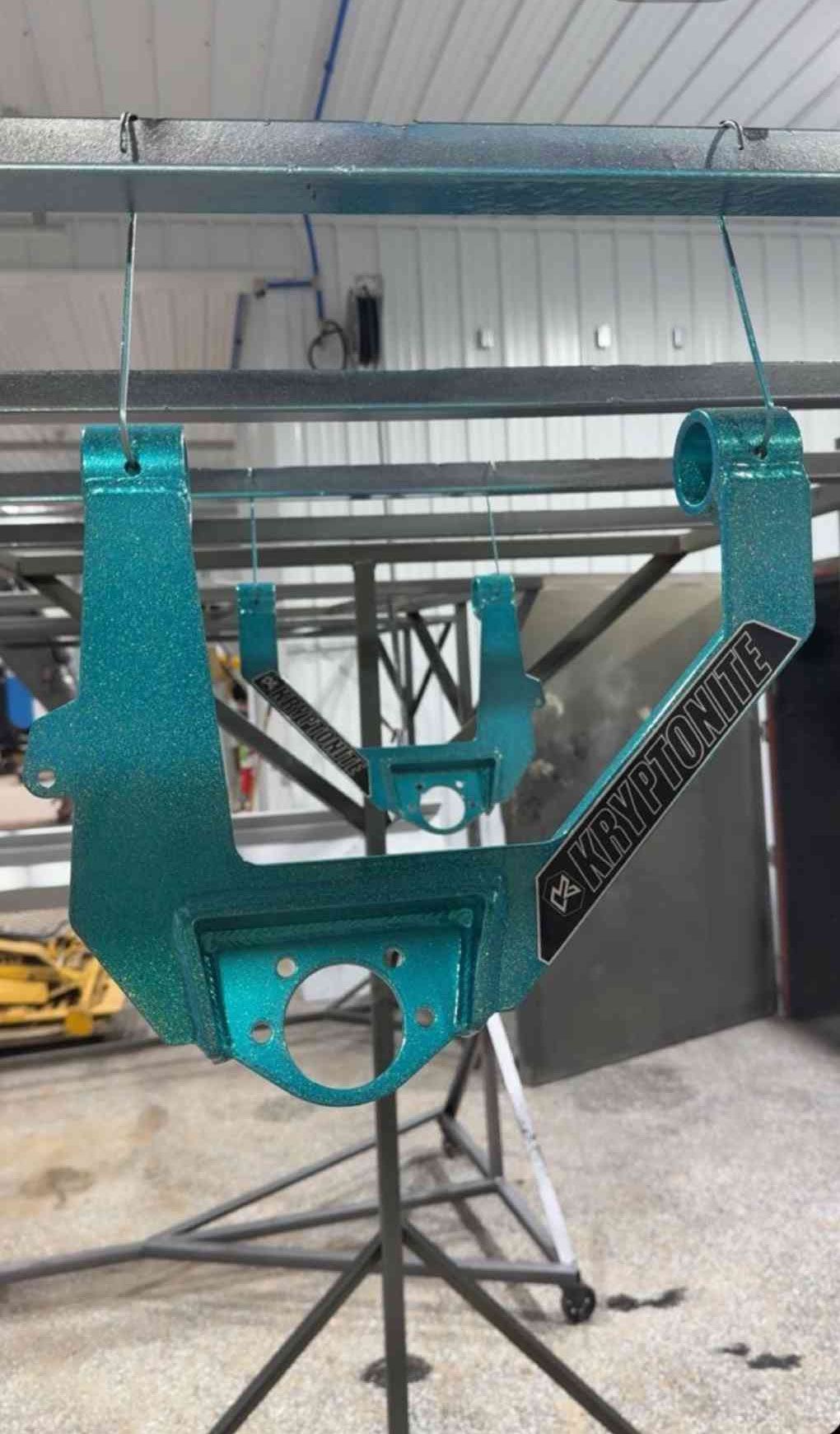 Turquoise metal machine frame on a stand in an industrial workshop