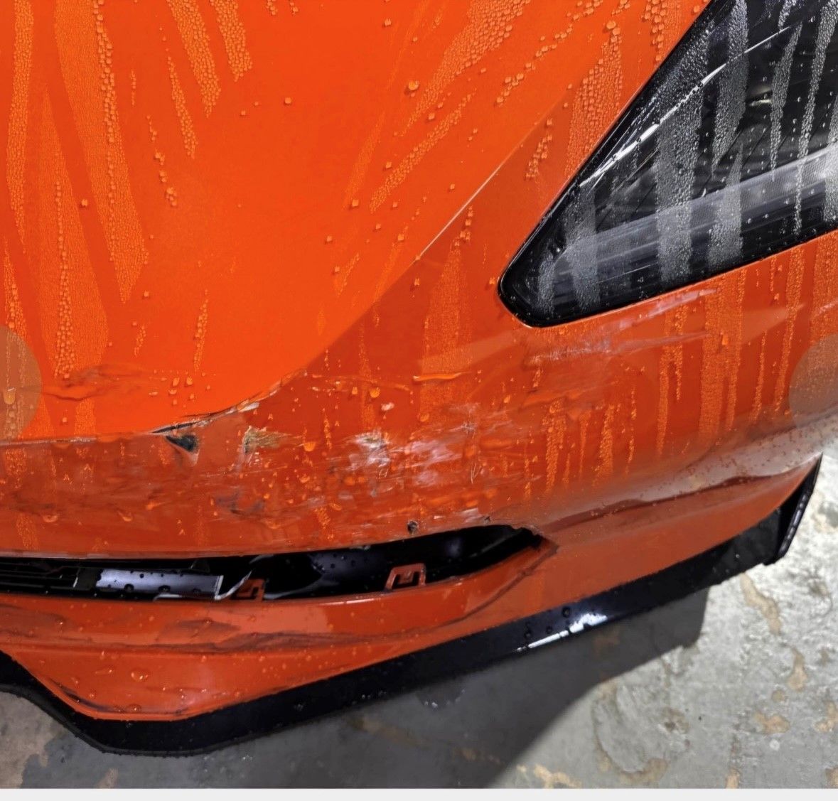 A close up of the front of an orange car