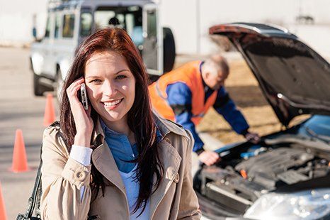 Happy woman and man trying to jump start a car