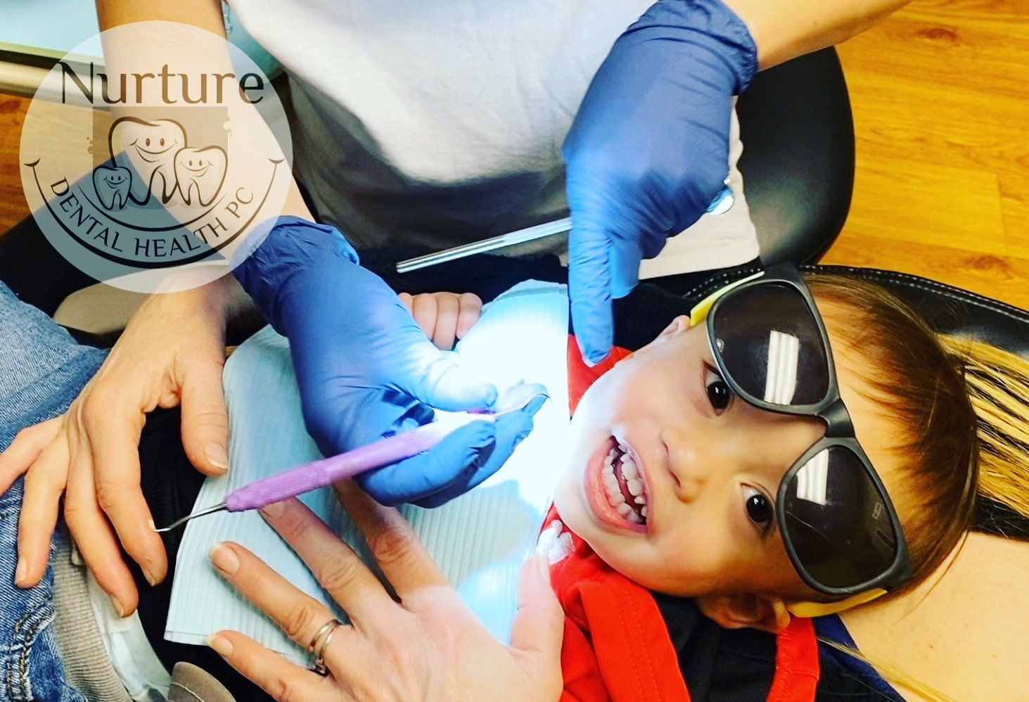 Toddler getting his teeth cleaned at a happy visit.