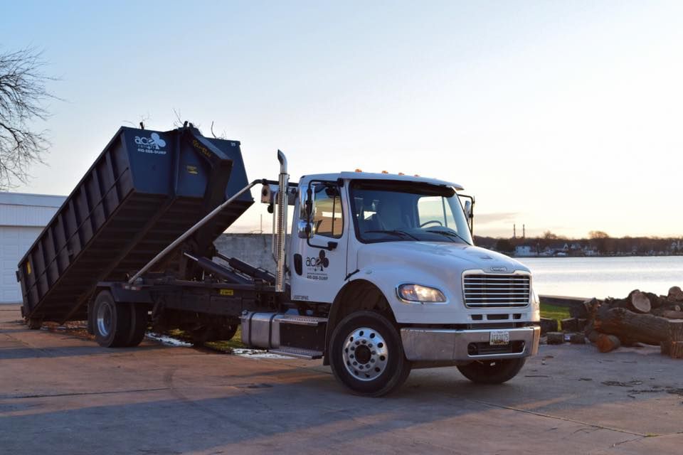 A dump truck is parked in a parking lot next to a body of water