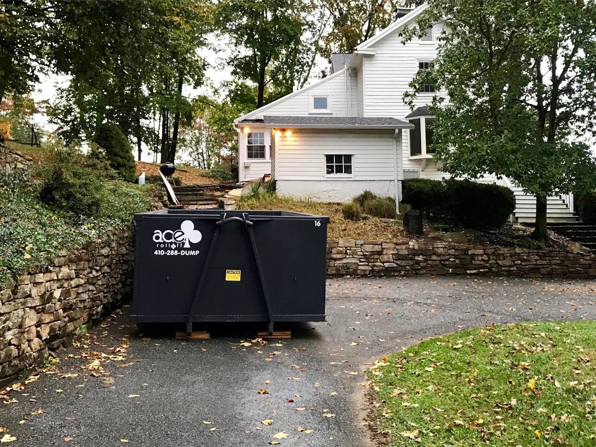 a dumpster is on a driveway in Parkville, MD