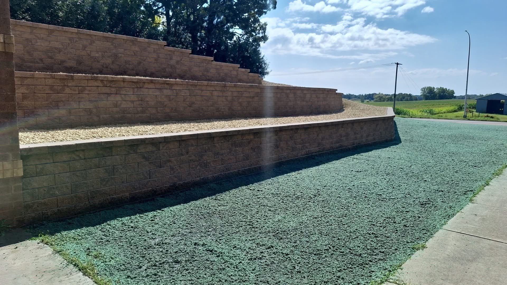 Tiered stone steps beside a gravel path and green lawn under a sunny sky