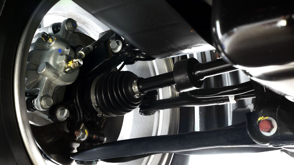 Car's front wheel and suspension system. Black components, silver wheel, gray tire.