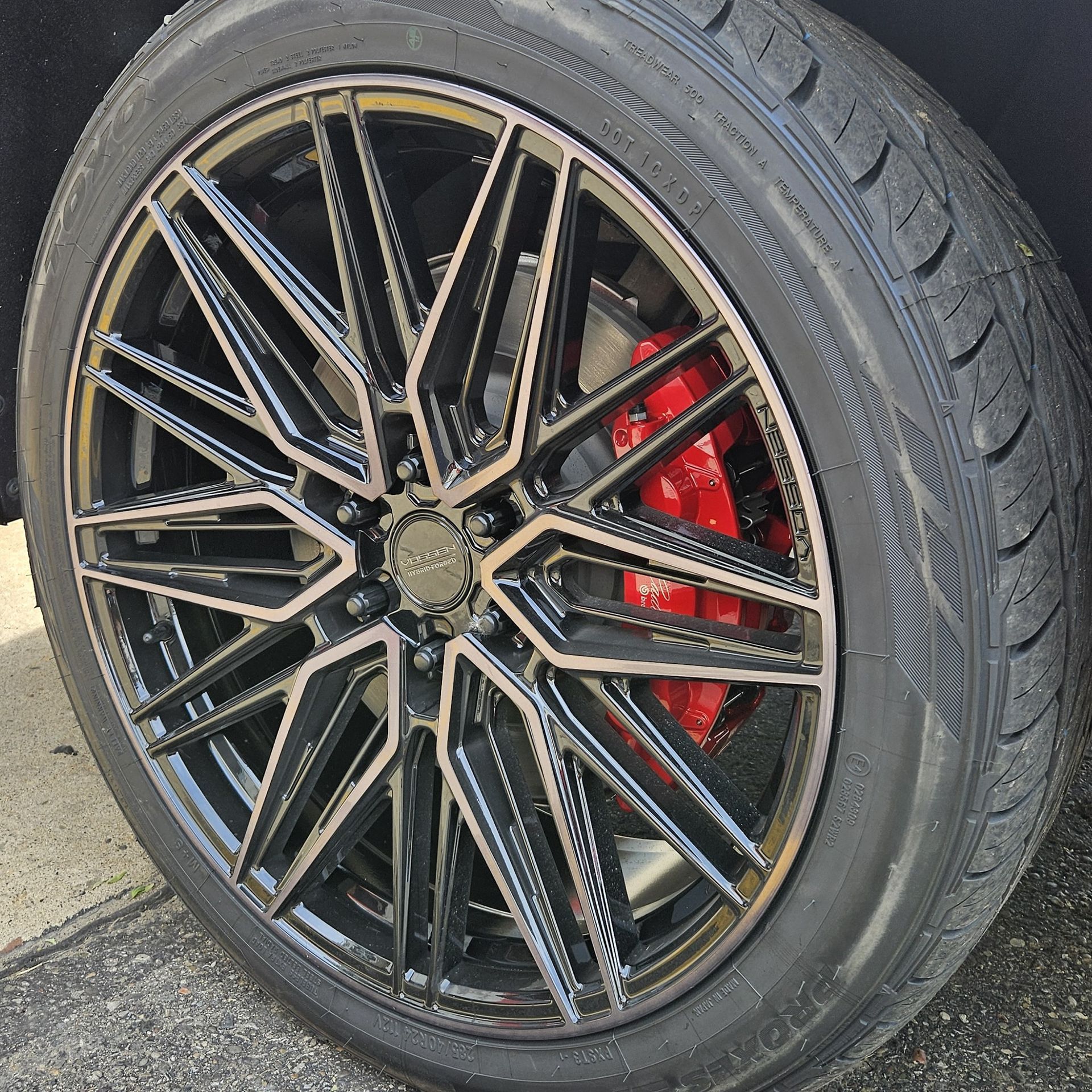 Black and bronze alloy wheel with a red brake caliper.