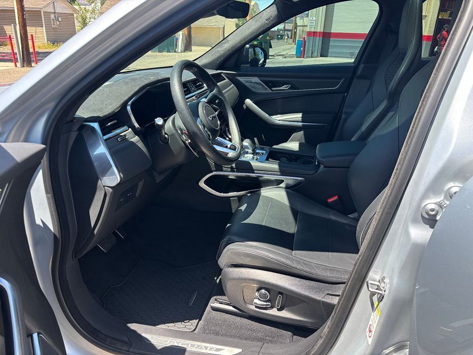 Interior view of a gray car, showing black leather seats, steering wheel, and dashboard.