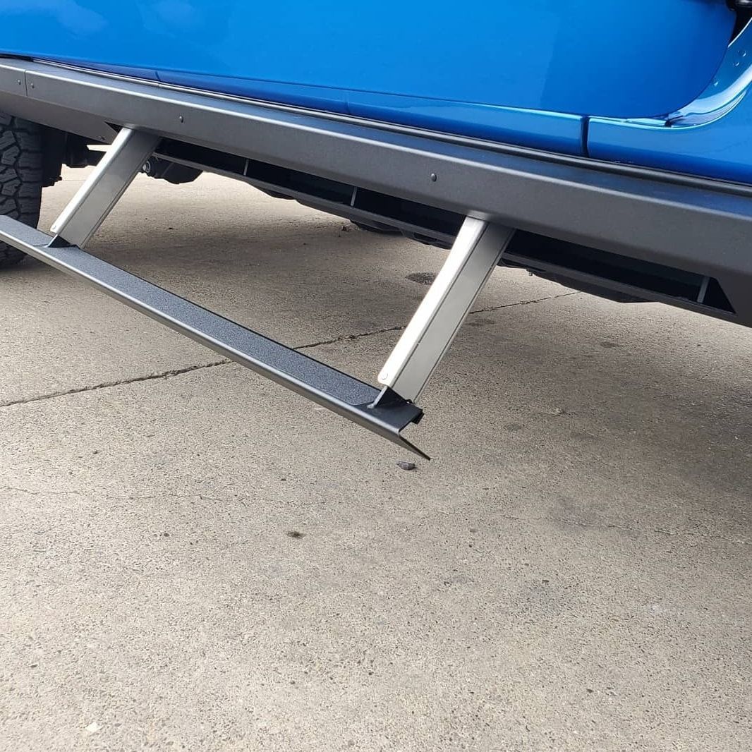 Blue truck with a silver running board and step extended.