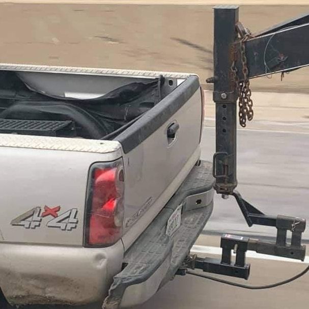 Silver pickup truck with a trailer hitch attached.