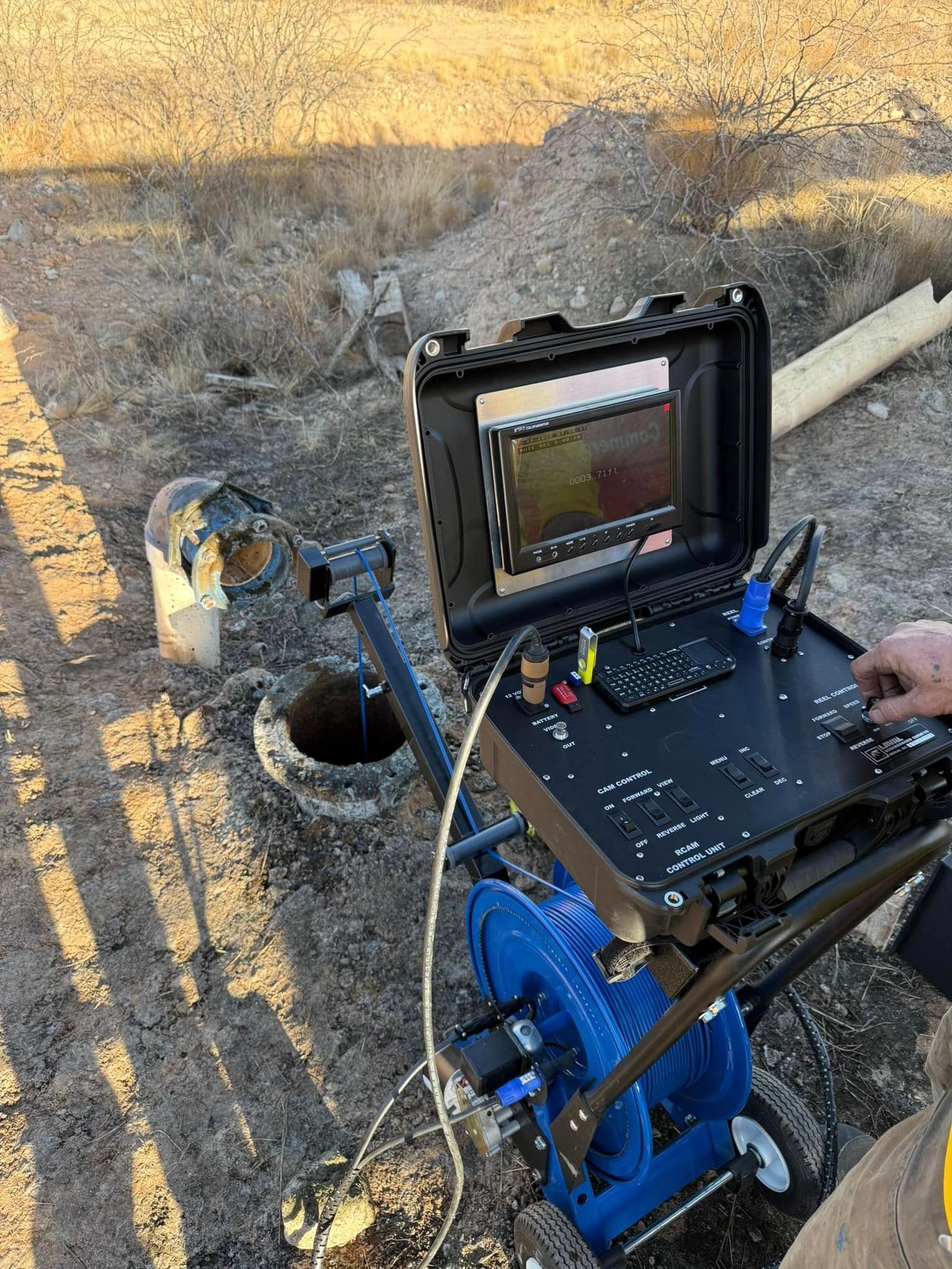 A person is using a laptop computer on a cart in the dirt.