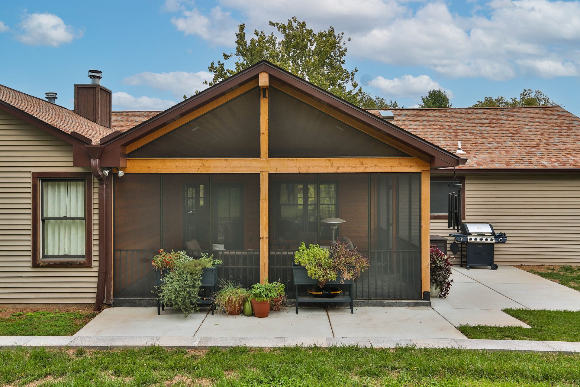 A house with a screened-in porch and a grill