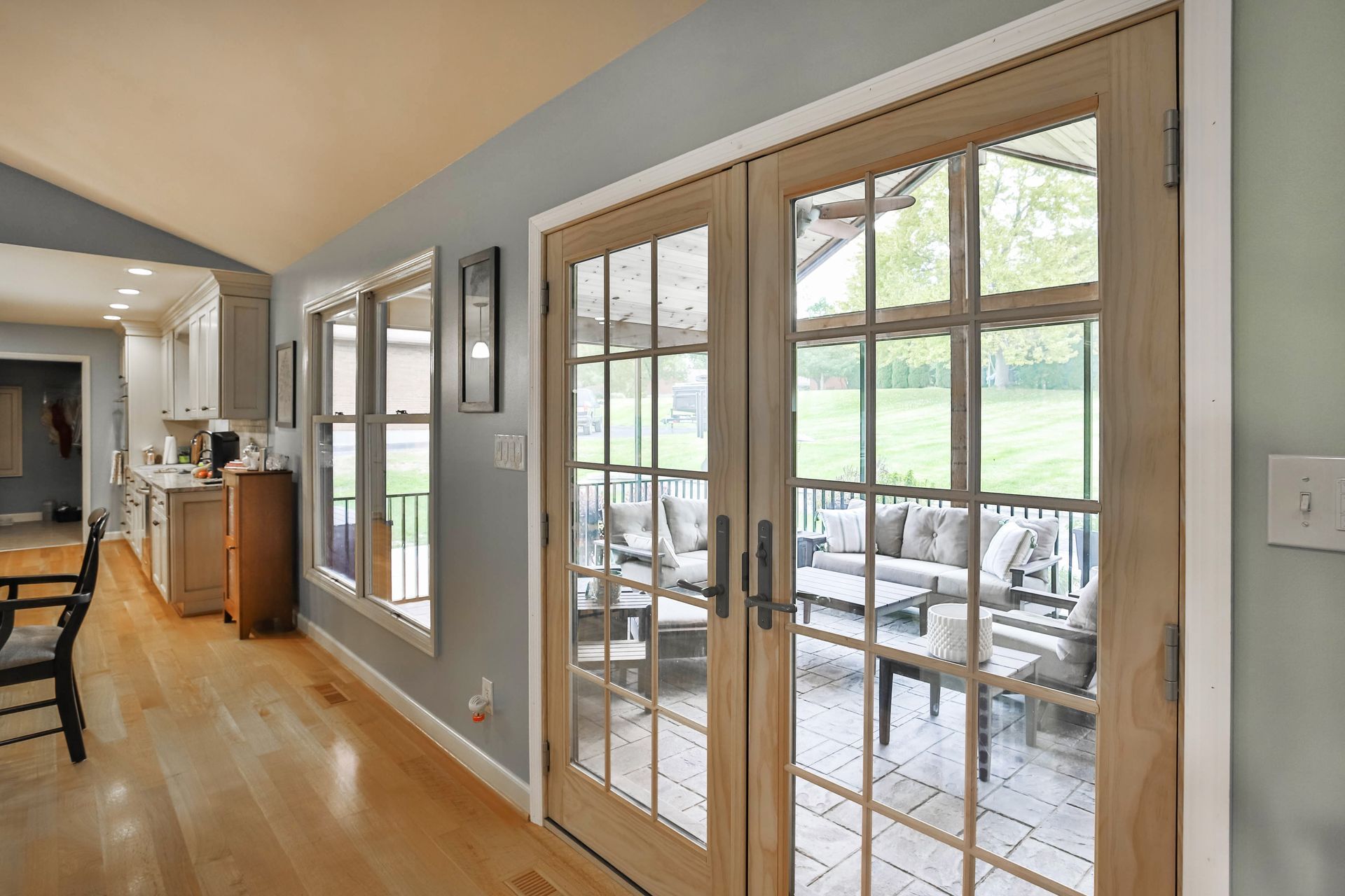A hallway in a house with french doors leading to a patio