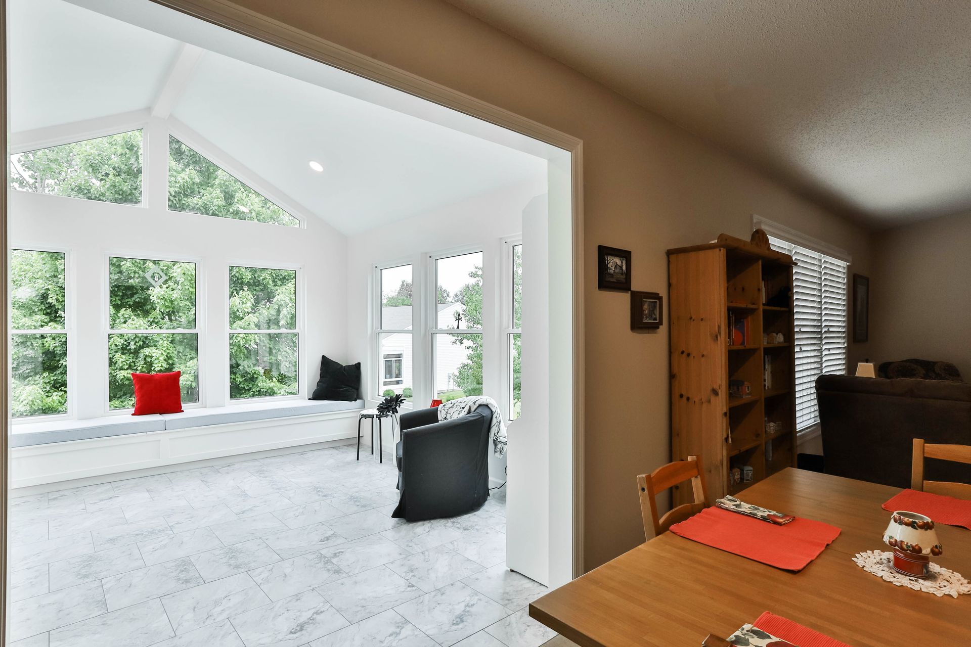 A room with a table and chairs and a window seat