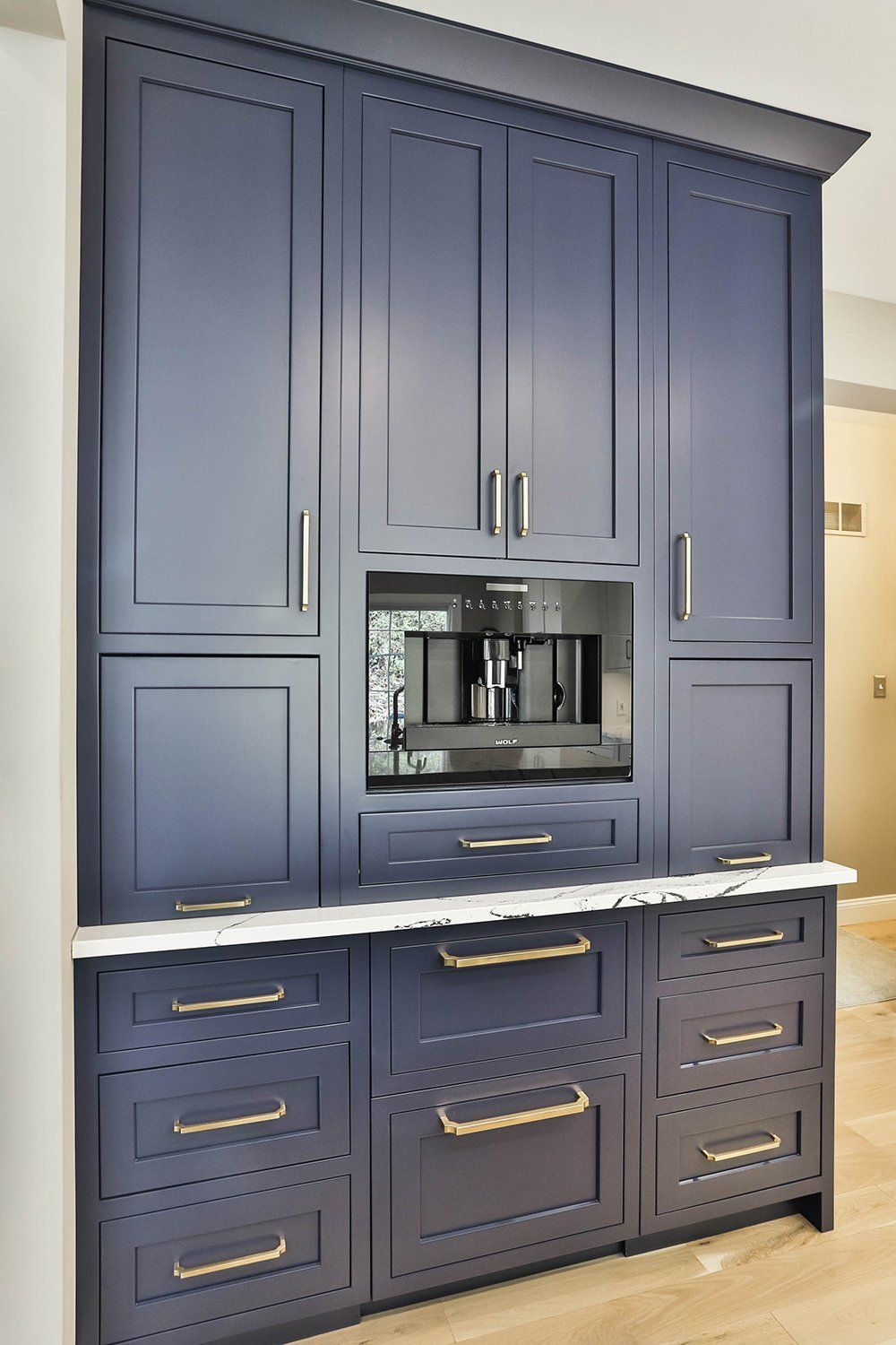 Blue kitchen cabinets with a coffee maker