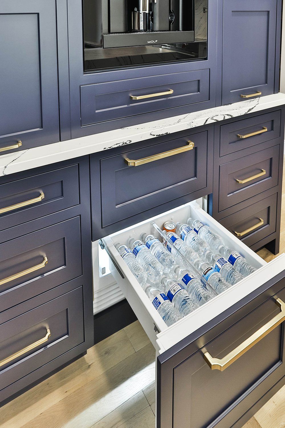 Blue kitchen cabinets with an open water drawer