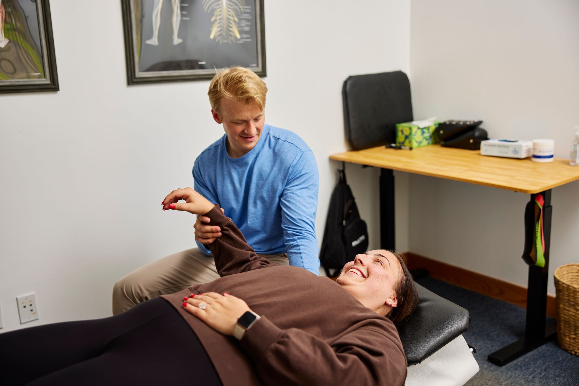 Chiropractor examining a patient on a treatment table in a clinic office.