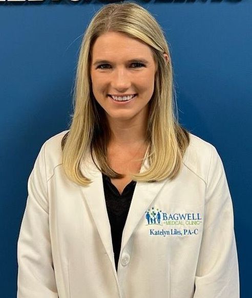 A woman in a white lab coat is smiling for the camera.