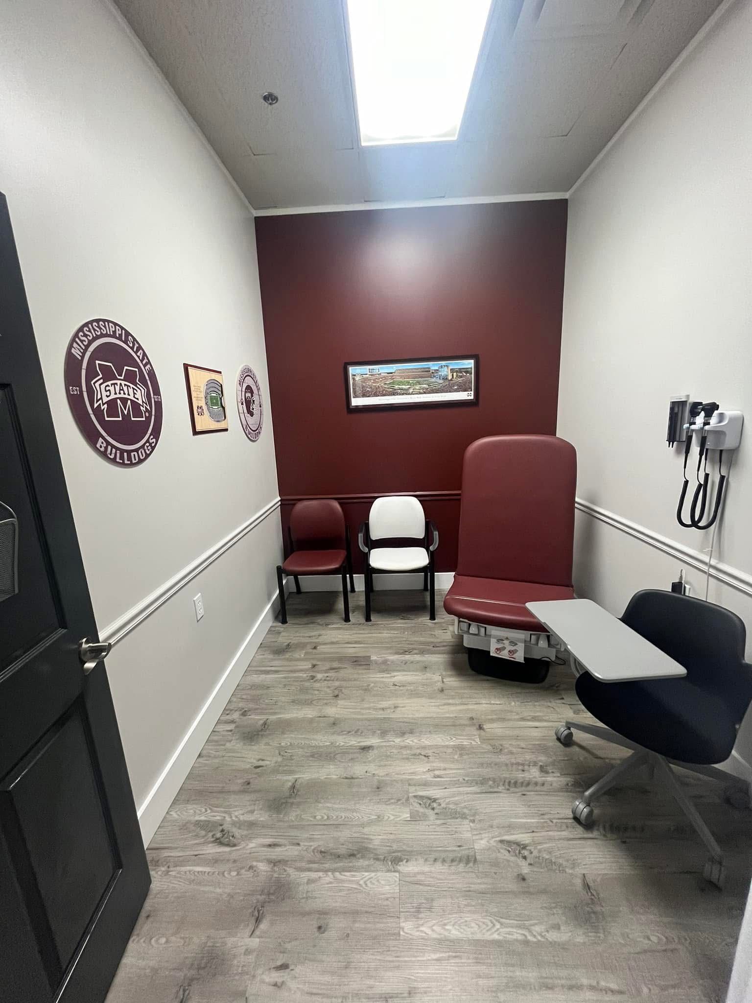 A waiting room with a red chair , chairs , and a stool.