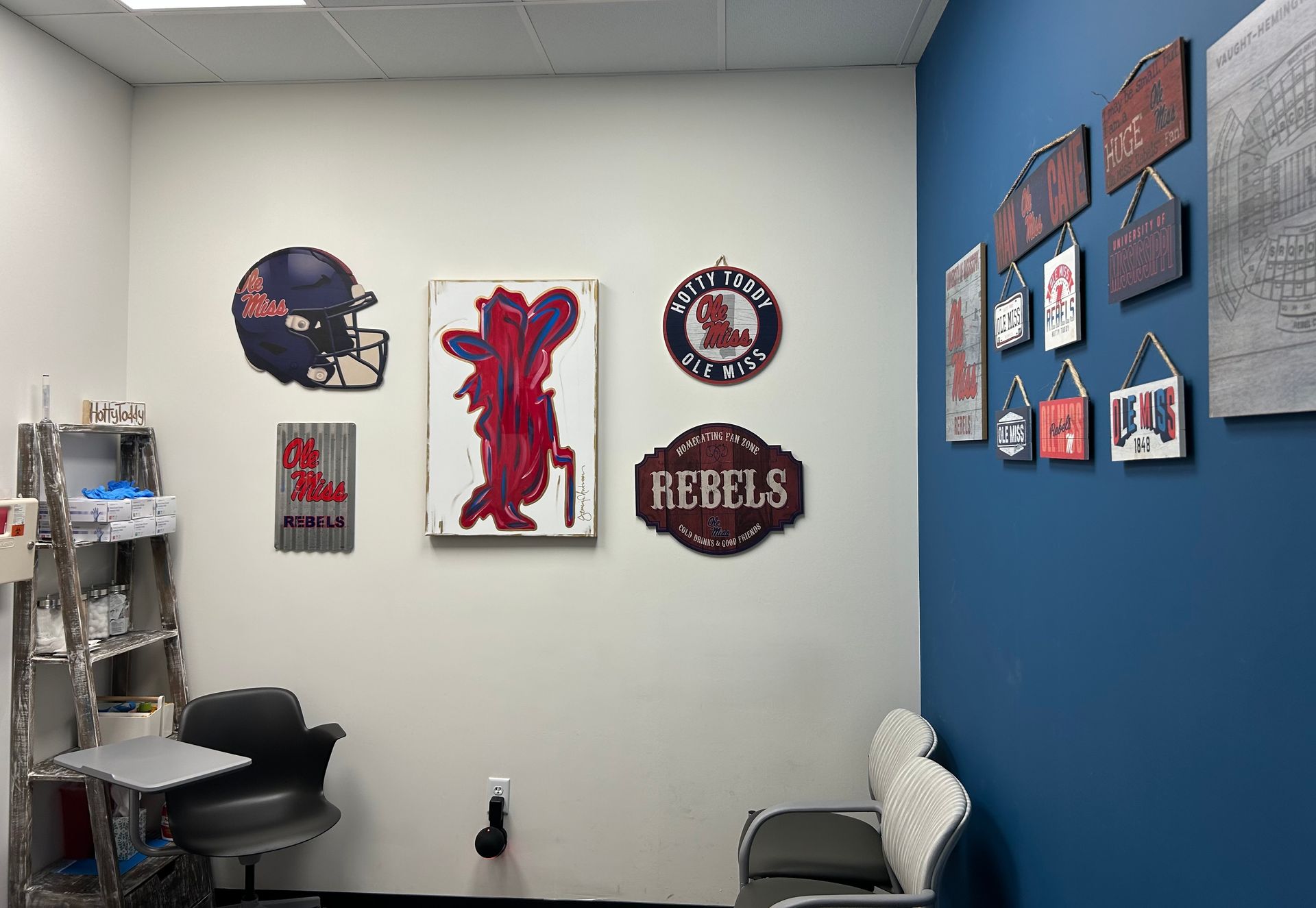 A room with a blue wall and a desk and chair.