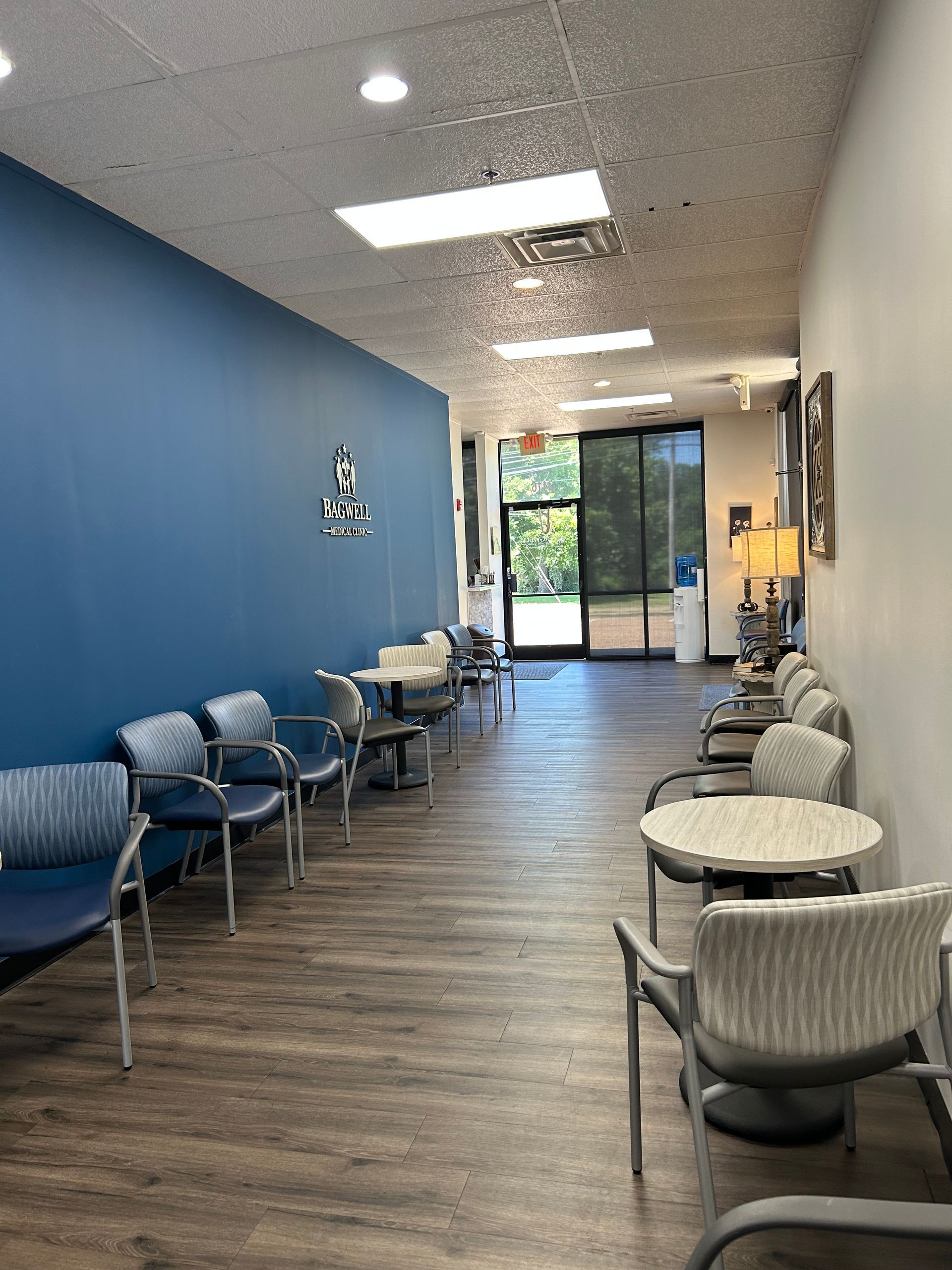 A long hallway with tables and chairs in a waiting room.