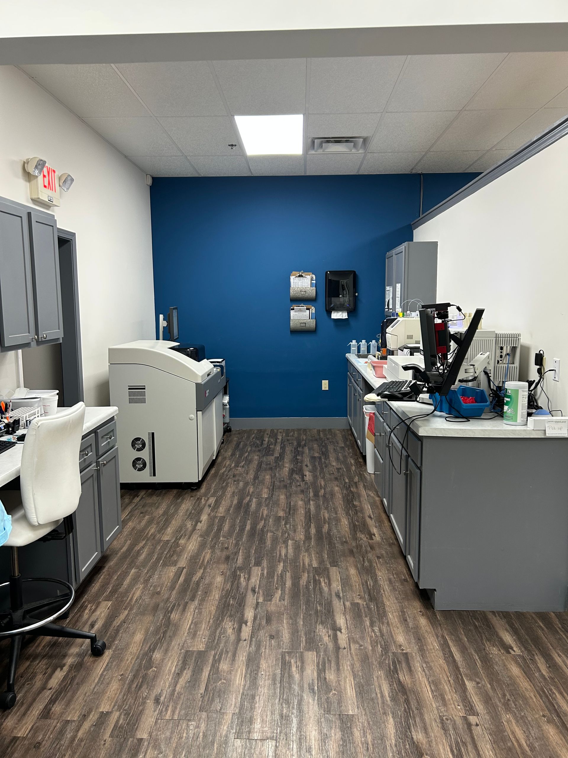 A laboratory with a blue wall and wooden floors.