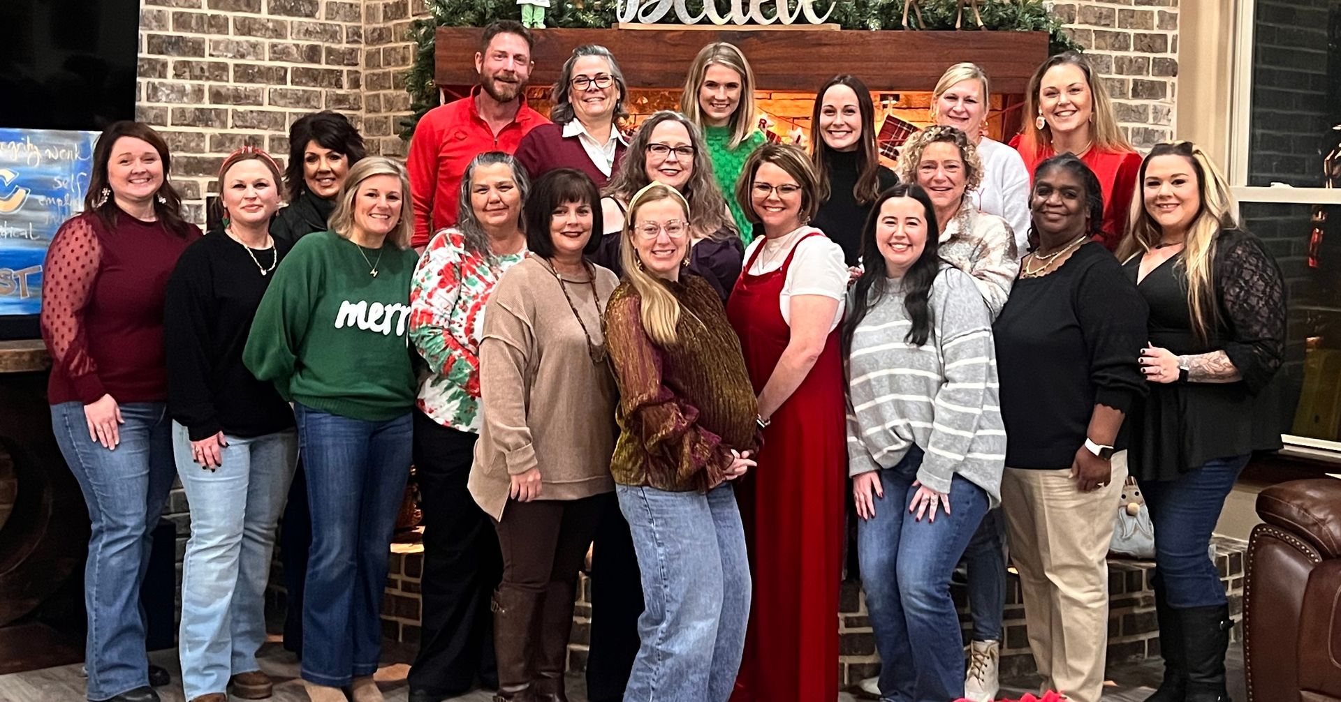 A group of people are posing for a picture in front of a fireplace.