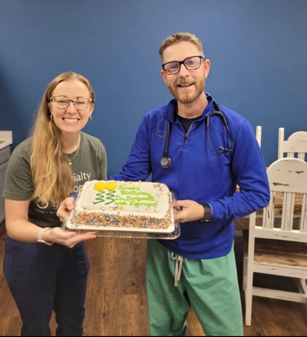 A man and a woman are holding a cake that says happy birthday