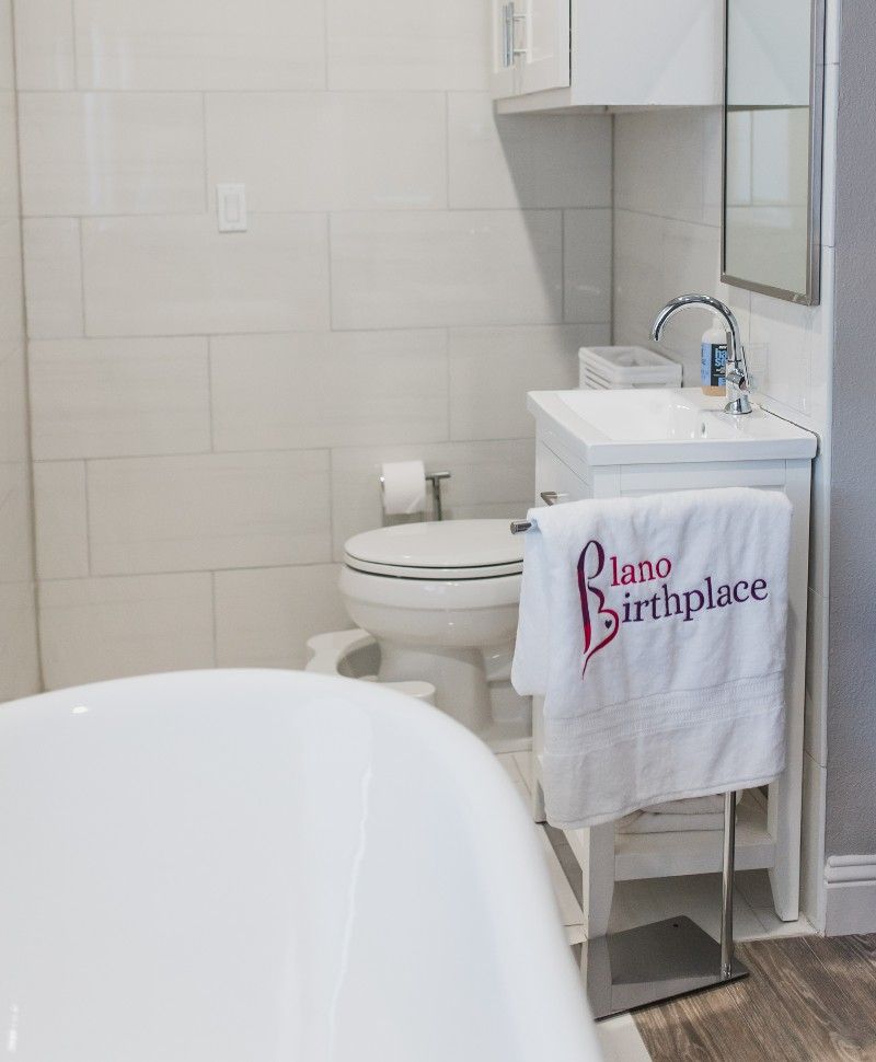 A bathroom with a bathtub , toilet , sink and mirror.