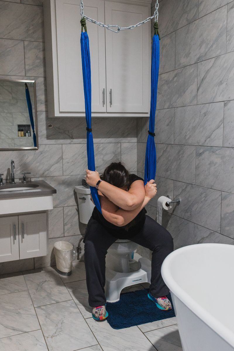 A woman is sitting on a toilet in a bathroom