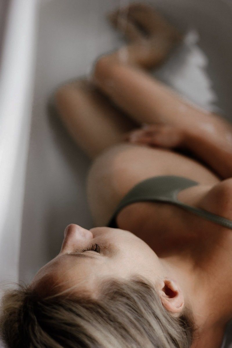 A woman giving birth in a bath tub