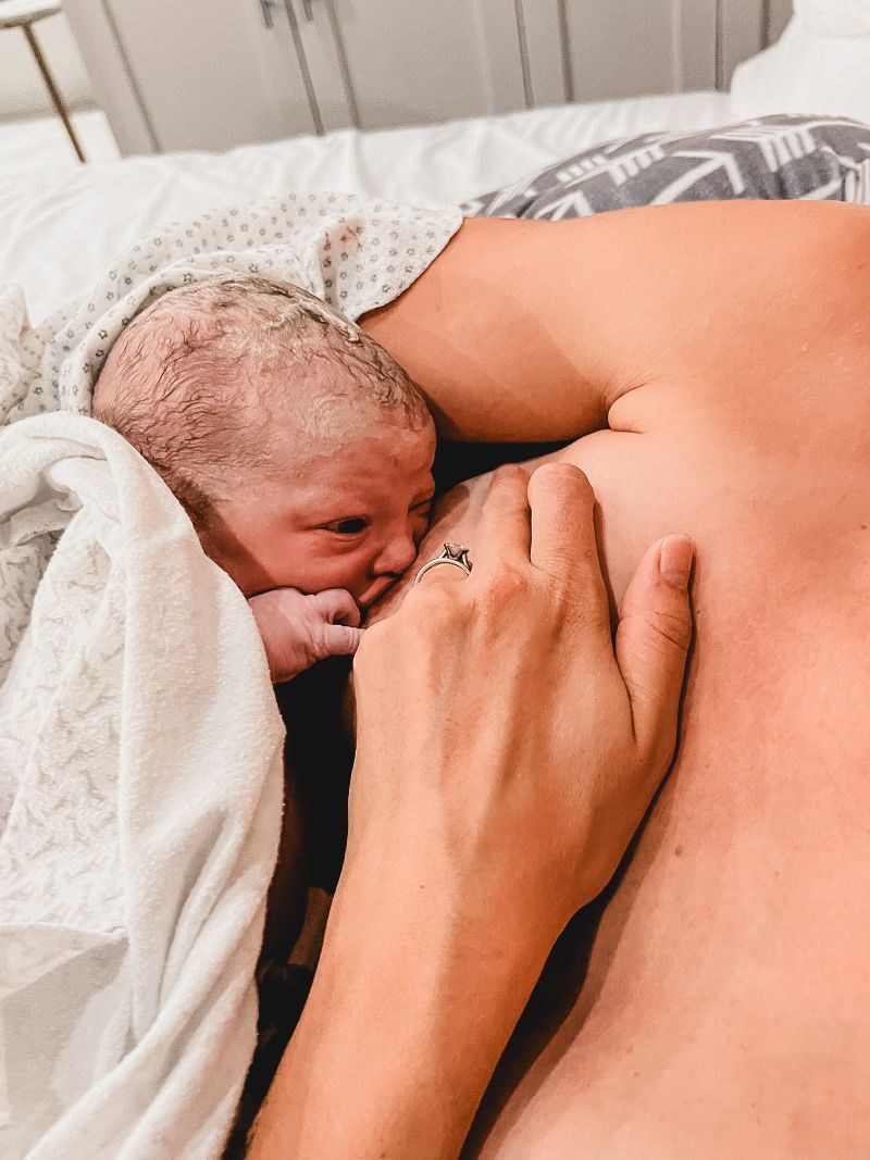 A woman is holding a newborn baby in her arms.