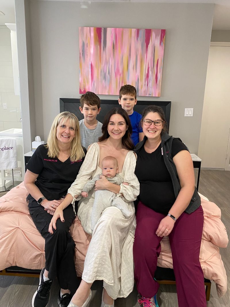 A group of people are posing for a picture while sitting on a bed.