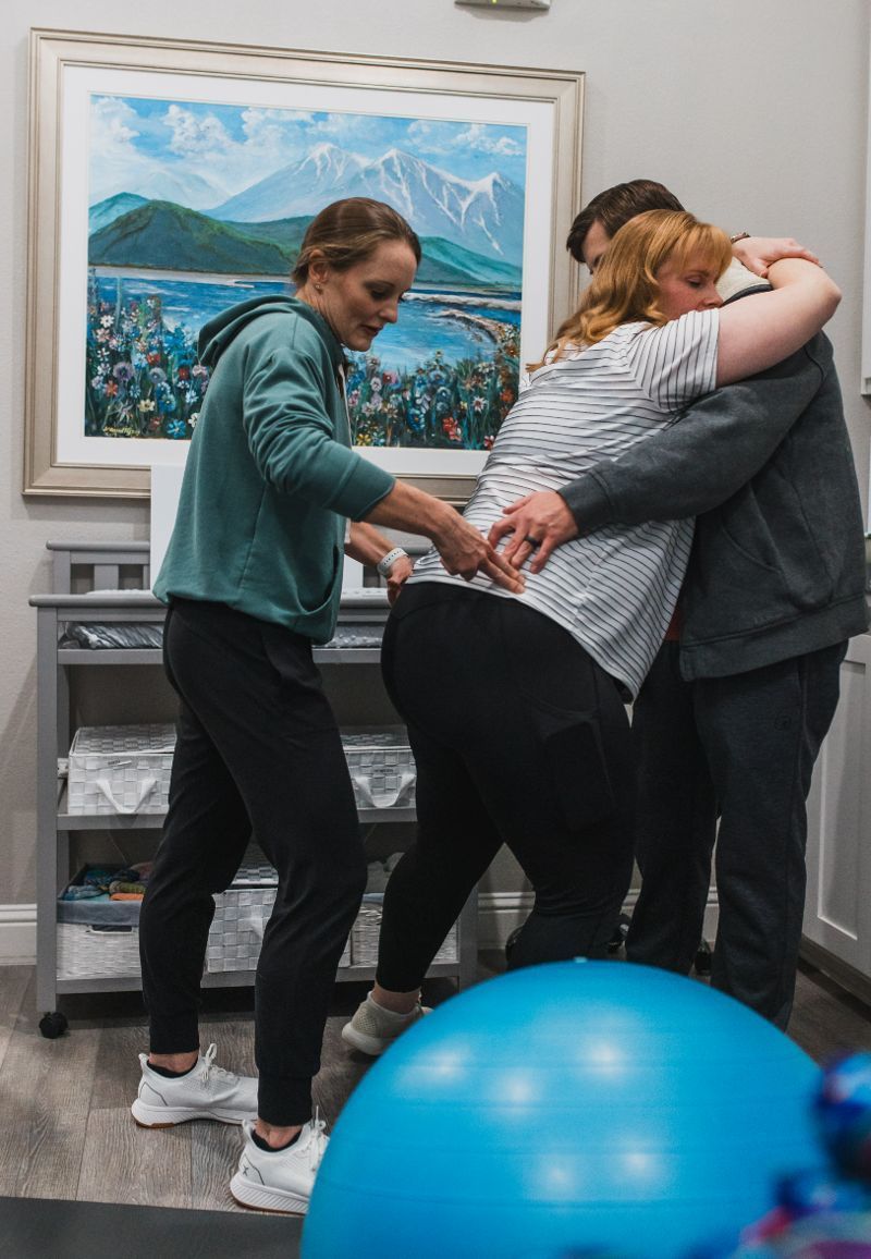 A group of people are helping a woman give birth in a room.