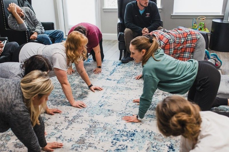 A group of people are doing push ups on the floor.
