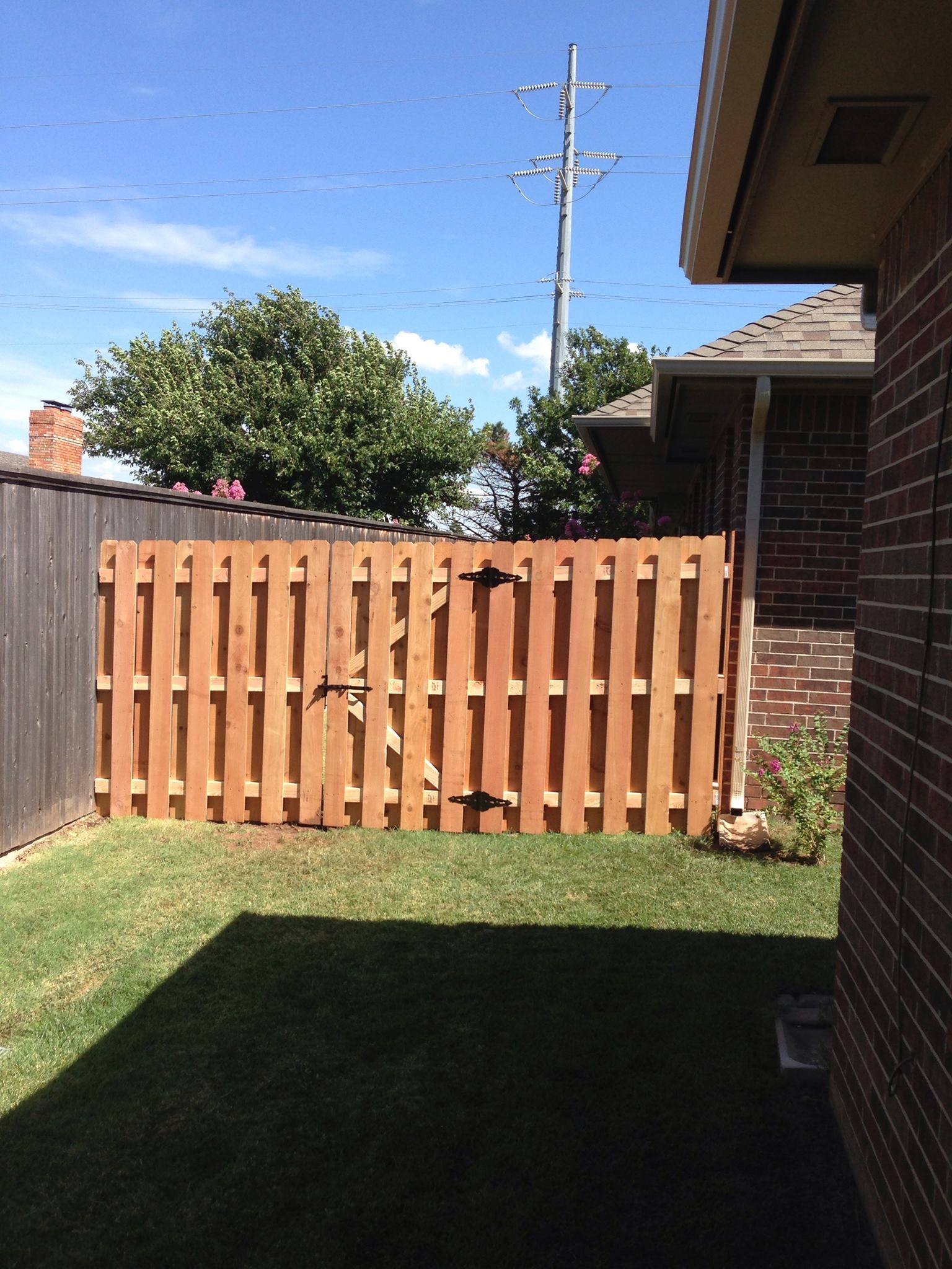 A wooden fence is in the backyard of a house
