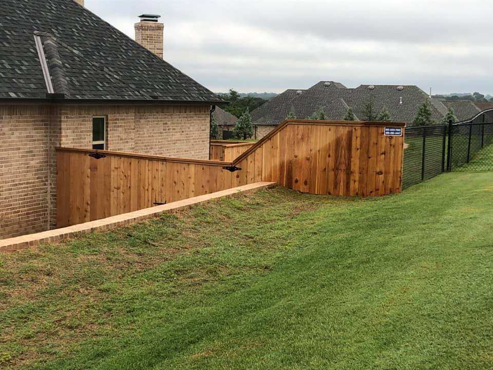 There is a wooden fence in the backyard of a house.