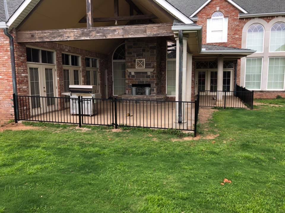 A large brick house with a covered patio and a fireplace.