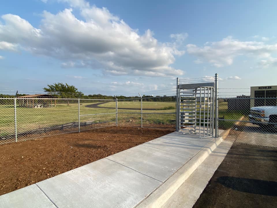 A white truck is parked in front of a fence