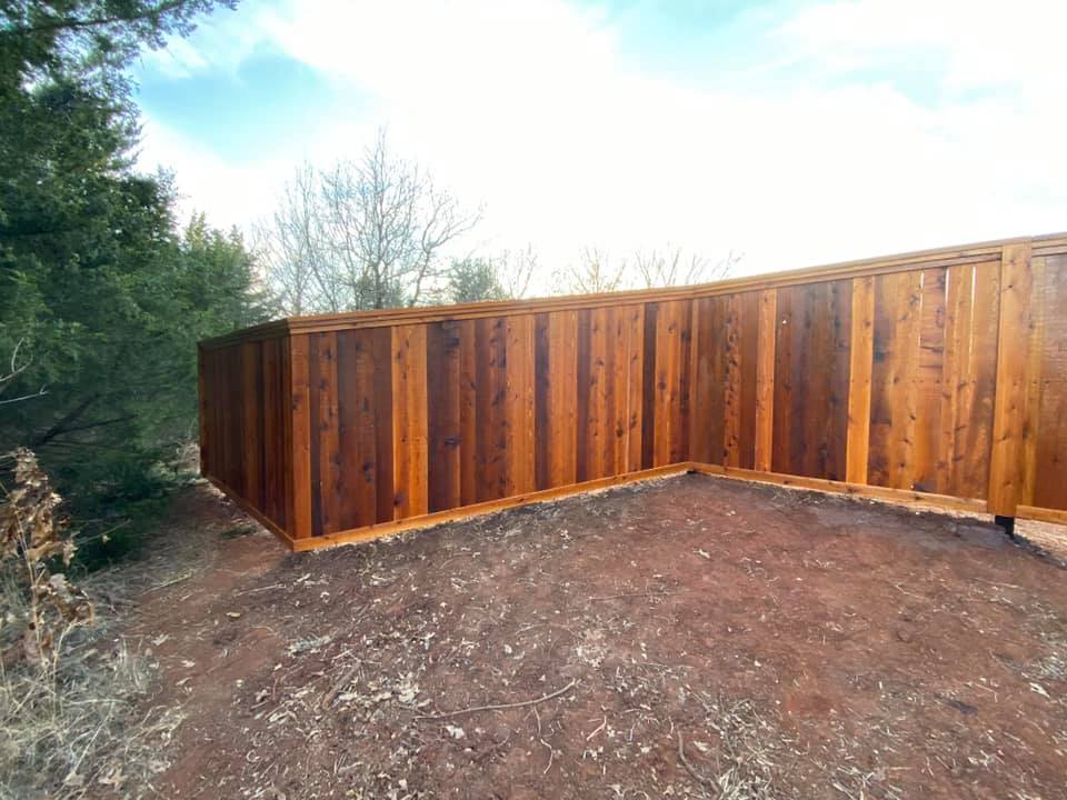 A wooden fence is sitting on top of a dirt hill.