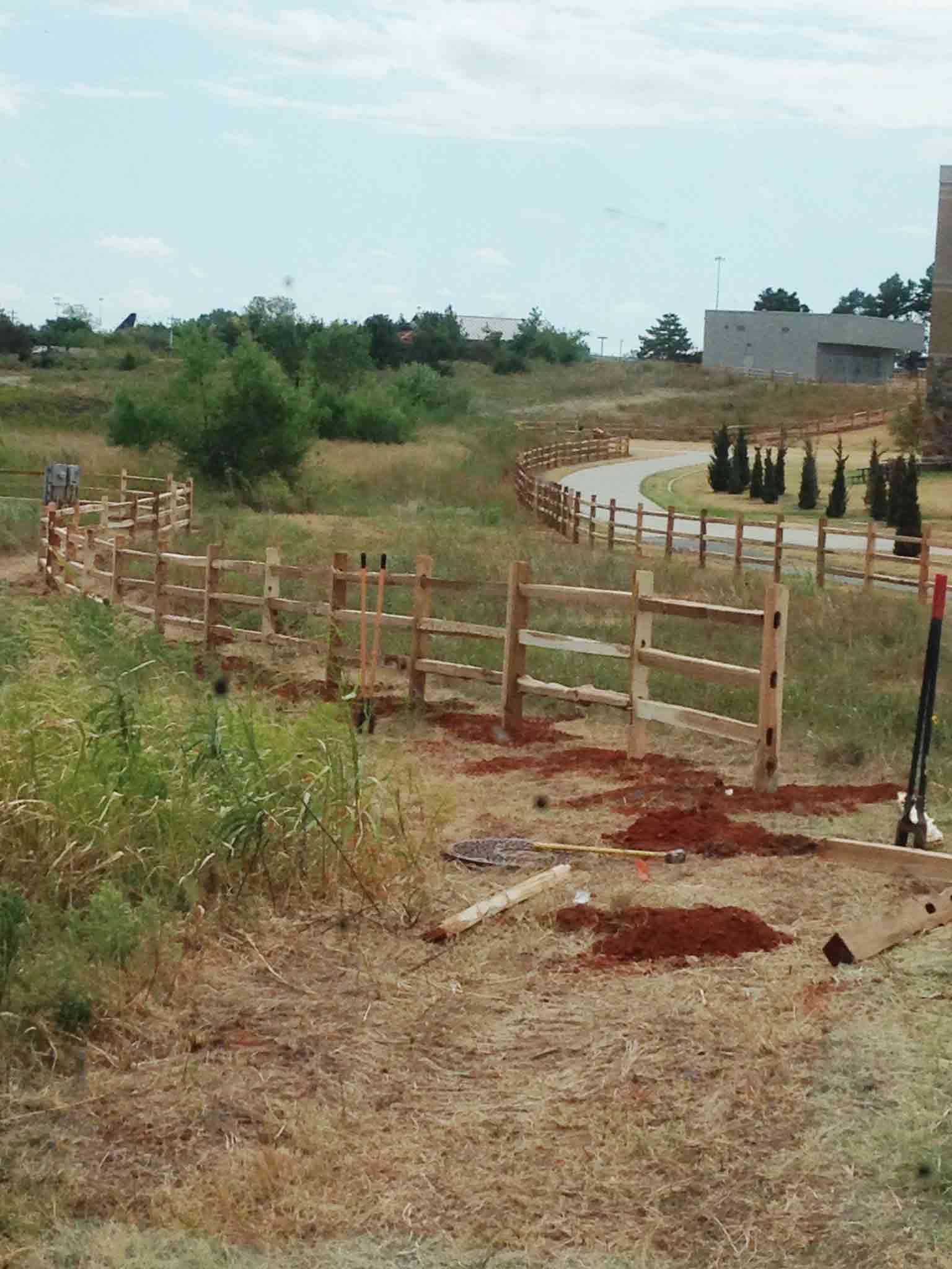 A wooden fence is being built in a field.
