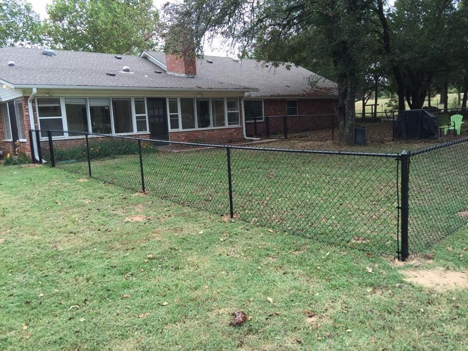 A house with a chain link fence in front of it.